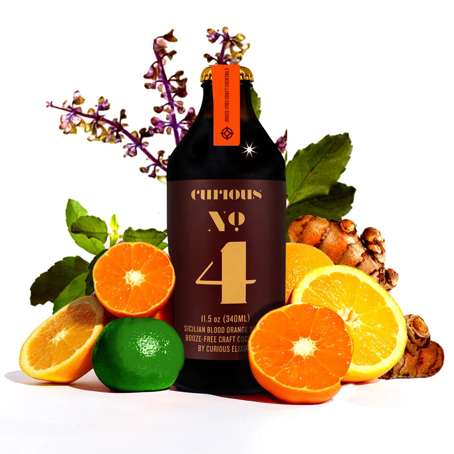 Curious No. 4, a non-alcoholic Sicilian Blood Orange Spritz, beside fresh blood orange and citrus.