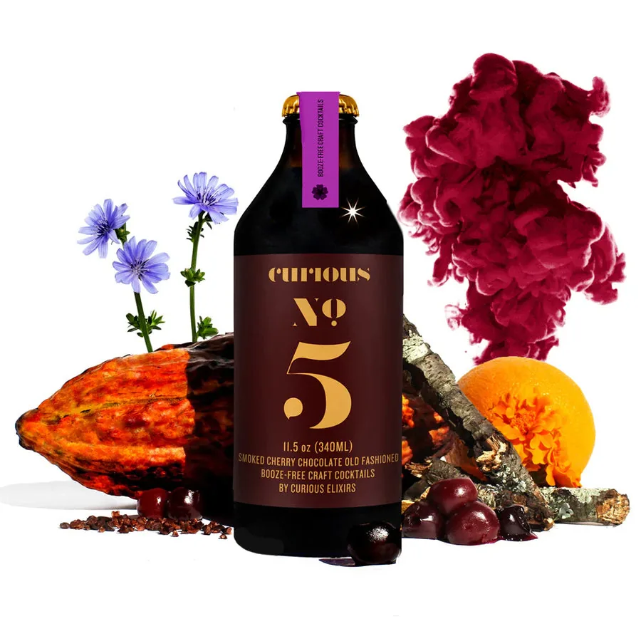 Curious No. 5, a non-alcoholic Smoked Chocolate Cherry Old Fashioned, beside cacao and dried cherries.