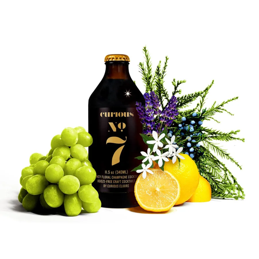 Curious No. 7, a non-alcoholic Sparkling Champagne Cocktail, beside green grapes and lemon.