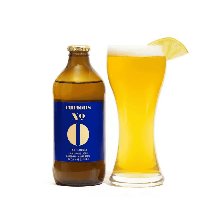 Curious Zero, a non-alcoholic Lion's Mane Lager bottle beside a poured glass with a lime.